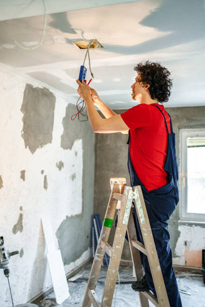 istock Electrician fixing electrical wires on a ceiling while renovating house 1502969442