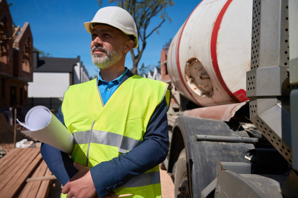 istock Bearded man in hi vis safety vest and hardhat looking at construction site 1502974197