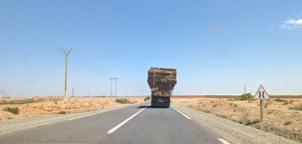 An overloaded truck driving through an arid landscape, Morocco
