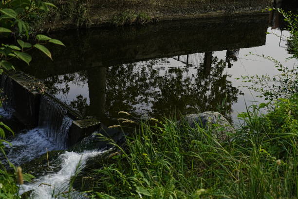 fishermen reflected in the water of a canal