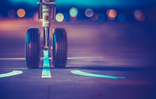 Airplane Wheels On The Runway Prior To Take-Off For A Red-Eye Flight At Sunset, With Copy Space