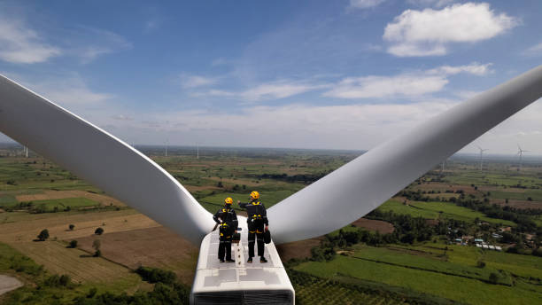 equipo de mantenimiento de turbinas eólicas senior y especialista trabajando en la parte superior con los soportes de potencia del motor de turbina, concepto de energía verde y revisable - alternative energy electricity wind turbine team fotografías e imágenes de stock