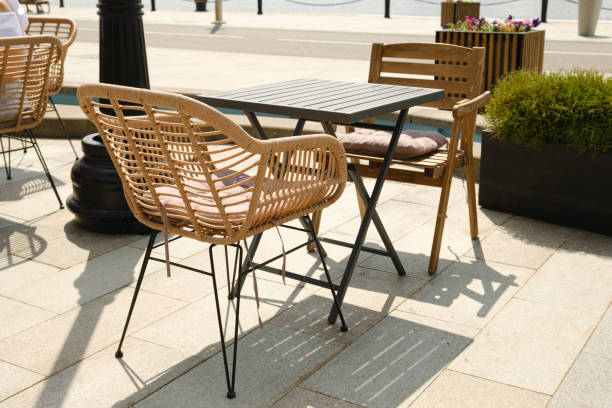 istock Empty tables and plastic wicker chairs on the summer terrace near a small cafe 1502985652