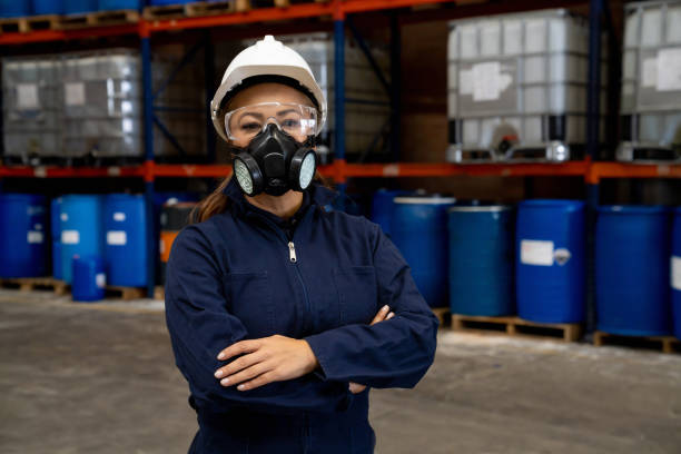 frau, die in einer chemiefabrik arbeitet und arbeitsschutzkleidung trägt - chemical worker stock-fotos und bilder