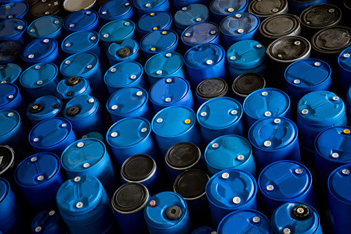 Stock of blue plastic barrels with hazardous substances at a chemical plant - manufacturing industry concepts