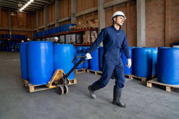 arbeiter in einer chemiefabrik bewegt fässer mit einem gabelstapler - chemical worker stock-fotos und bilder