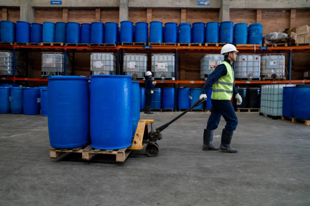 istock Man working at a chemical plant moving barrels using a forklift 1502990393