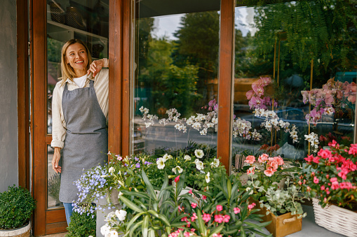 Woman florist small business owner standing in floral store. High quality photo