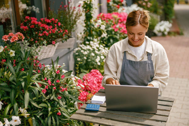 istock Smiling florist working on laptop and taking online orders in store 1502997050