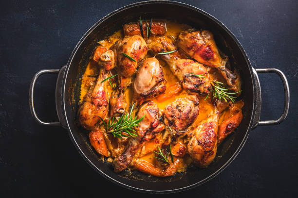 istock Baked chicken drumsticks with vegetables, casserole dish on black background 1502997278