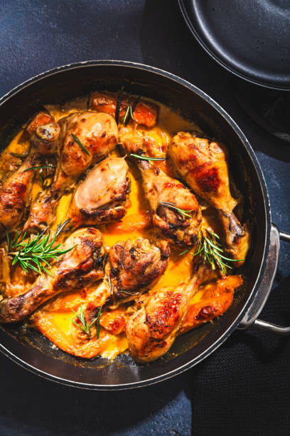 istock Baked chicken drumsticks with vegetables, casserole dish on black background 1502997279