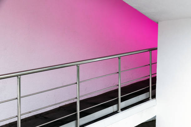 Abstract white minimal interior background with purple illumination of a stairway with metal railings, architectural photo