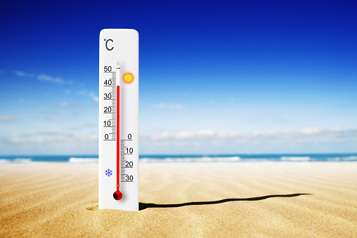 Hot summer day. Celsius scale thermometer in the sand. Ambient temperature plus 40 degrees