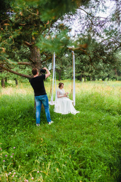 istock Videographer shoots a film with a bride on a rope swing 1503012161