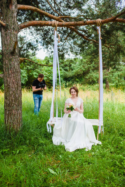 istock Videographer shoots a film with a bride on a rope swing 1503012165