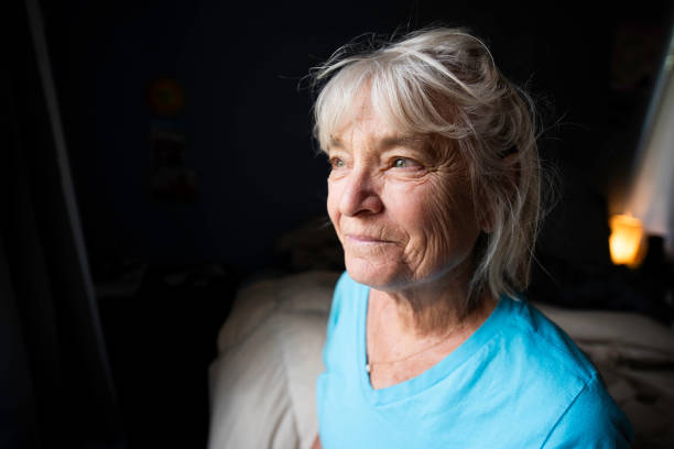 istock Beautiful elderly woman reading in bed by the window light 1503012287