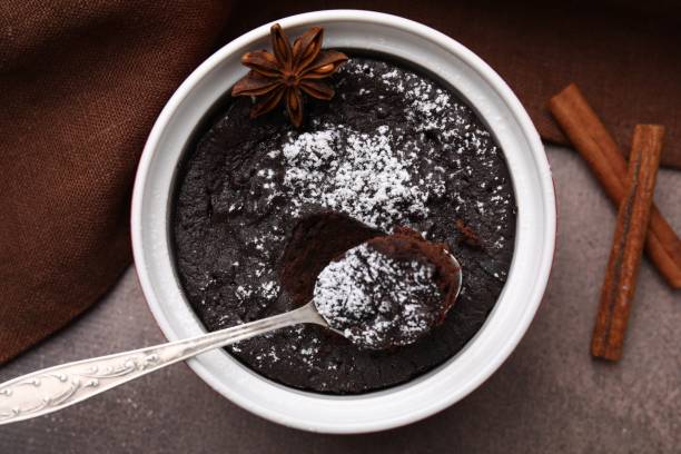 istock Tasty powdered chocolate pie with anise and spoon on brown table, flat lay. Microwave cake recipe 1503012517