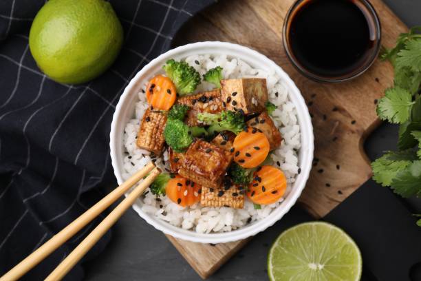 délicieux riz au tofu frit, brocoli et carottes servi sur table en bois gris, pose à plat - tofu chinese cuisine vegetarian food broccoli photos et images de collection