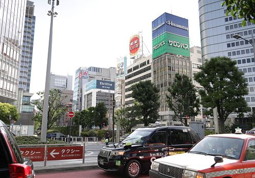 May 27, 2023 - Chuo Ward, Japan: Tall buildings stand in the Yaesu district of Chuo City. Foreground shows fleet of taxi cabs outside Tokyo Station.