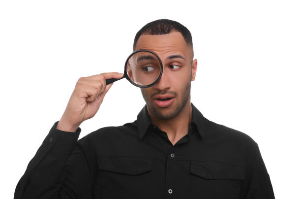 istock Surprised man looking through magnifier glass on white background 1503016637