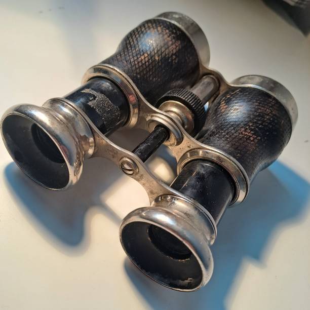 istock two vintage looking binoculars sitting on a table near a cell phone 1503021028