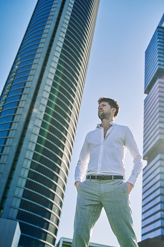 portrait of a young businessman outdoors with office buildings in the background