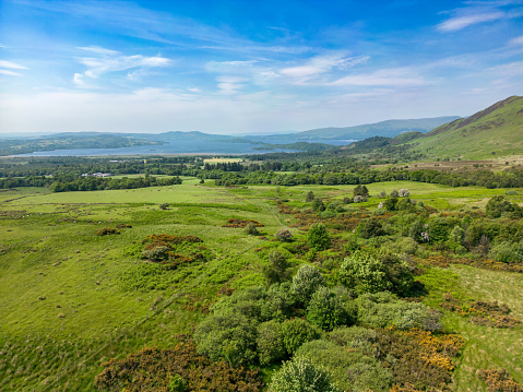Aerial view of Scottish Highlands with Loch Lomond in the distance.