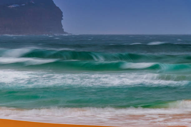 Sunrise seascape with rain and grey skies at Macmasters Beach on the Central Coast, NSW, Australia.