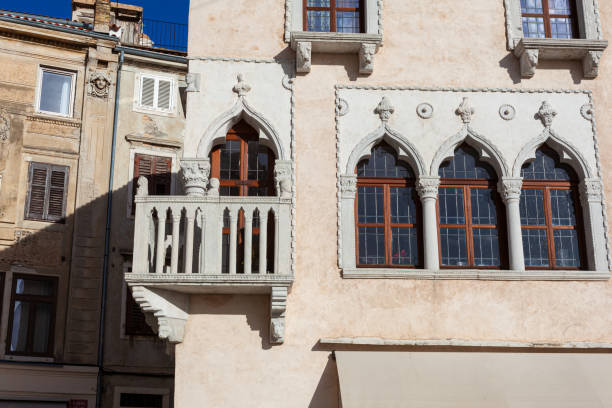 Piran, Slovenia - January 14, 2023: The Venetian house with Gothic architecture from the mid-15th century features a triple-lancet window and a corner balcony with a stone balustrade in Tartini Square.