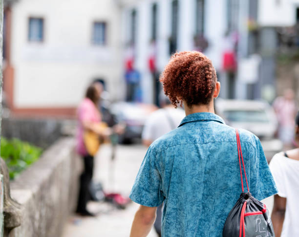 istock Young man watching buskers in a colonial town during vacation 1503054769