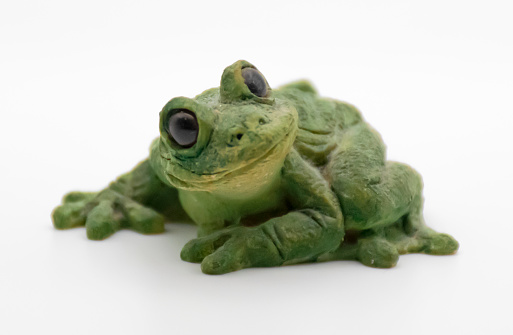 Cute green ceramic frog isolated on white background