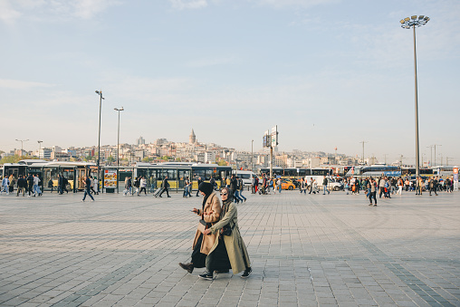 Istanbul, Turkey, May 02, 2023: Pedestrians on eminenu square overlooking the Galata Tower