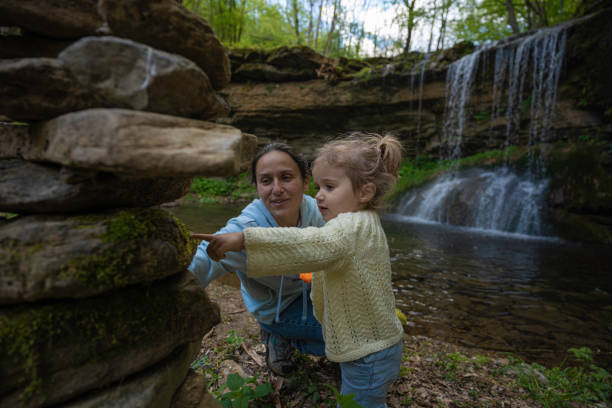 istock Mom and daughter play at waterfall in spring. 1503060746