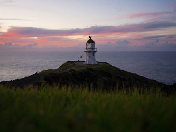 istock Panoramic view of historic white Cape Reinga lighthouse landmark on oceanside clifftop during sunset in New Zealand 1503064319