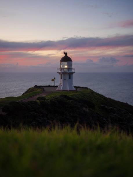 istock Panoramic view of historic white Cape Reinga lighthouse landmark on oceanside clifftop during sunset in New Zealand 1503064320