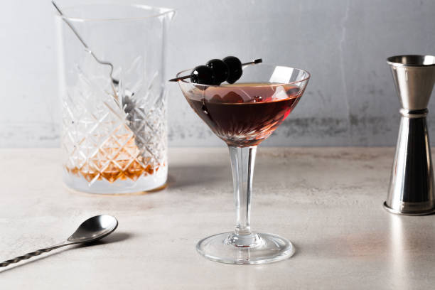 манхэттенский коктейль, алкогольный бурбон, виски, сладкий вермут и биттеры, вишня в качестве гарнира - manhattan cocktail cocktail drink cherry стоковые фото и изображения