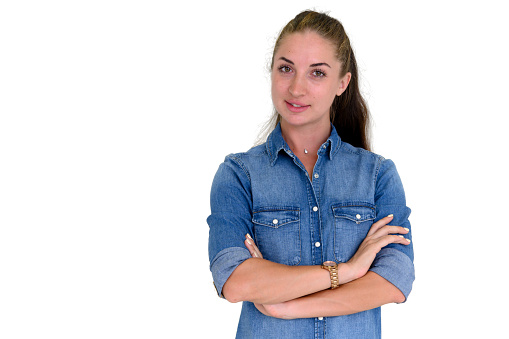 Portrait of beautiful woman in blue jeans shirt, crossed arms posing and standing on white background with copy space. Looking at camera