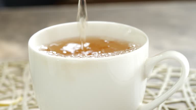 Elegant Tea Pouring Over White Glass in a Restaurant.