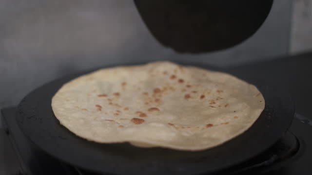 Unrecognizable Man Turning Tortilla (Flatbread) On Flat Pan