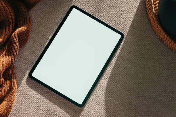 istock Tablet mock-up in natural light. Device with a blank screen on the light fabric 1503110377