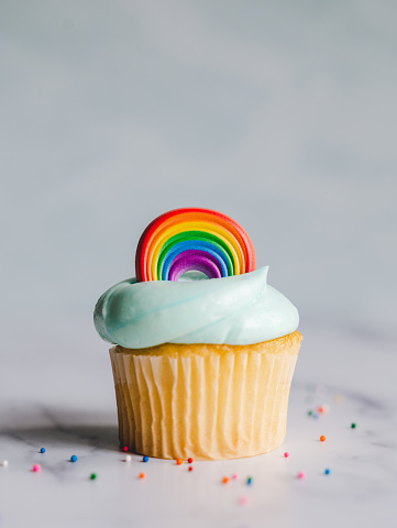 Vanilla cupcakes decorated with pride rainbow on white background. in Kingston, Ontario, Canada