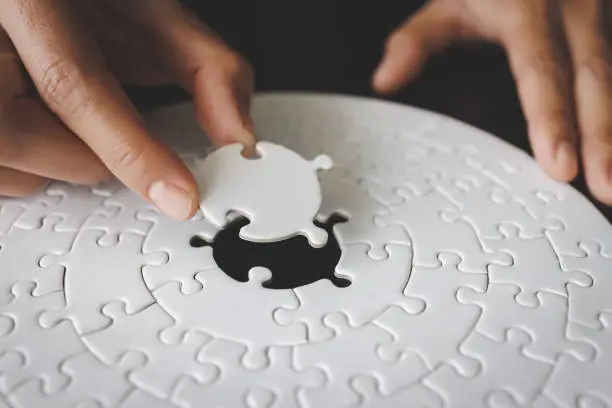 Concept of business, Hand put the last piece of jigsaw puzzle to complete the mission.