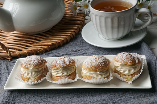 Cream puffs filled with pastry cream and sprinkled with powdered sugar