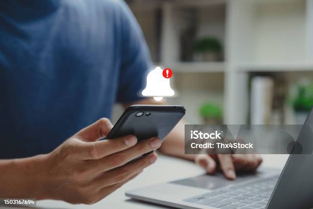Young Man Using Phone With Danger Alert Stock Photo - Download Image Now - Notification Icon, Alertness, Accidents and Disasters