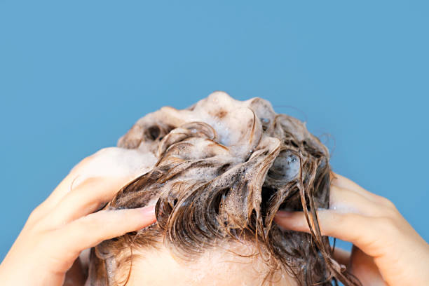 istock Girl washes her hair with shampoo on blue background, front view 1503172714
