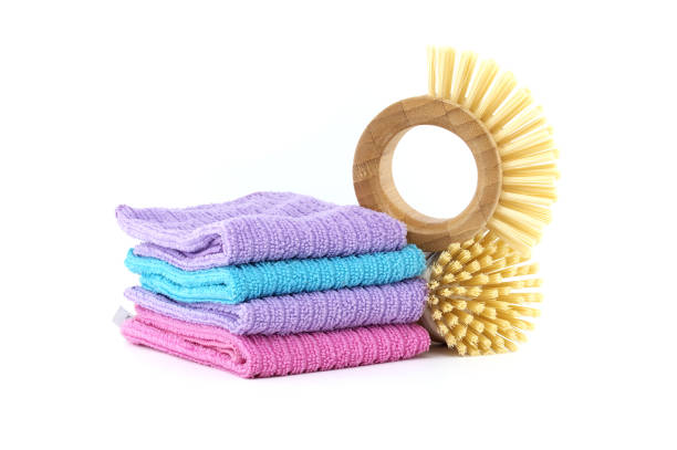 Highly detailed perspective image of multiple dish brushes and dishcloths in pastel colors isolated on white background