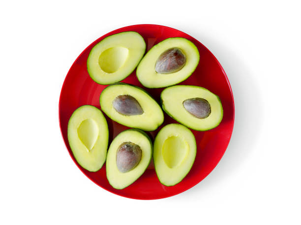 Three avocado halves on a white plate