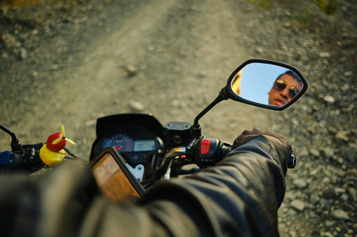 motorcyclist looking in the rearview mirror of his motorcycle