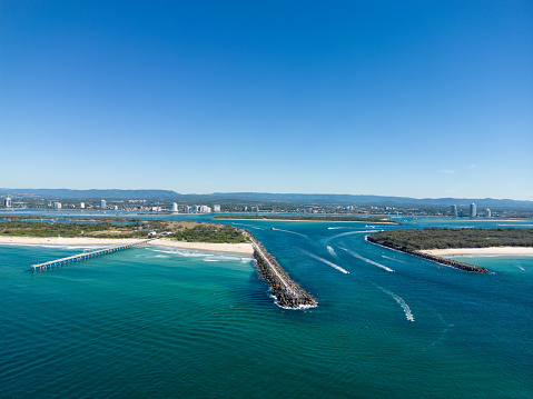 Aerial view of the rock wall, beach and river at the entrance of the Gold Coast Seaway, Gold Coast, Australia
