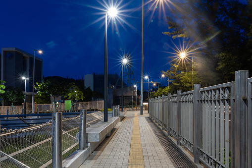 Urban sidewalks illuminated by street lights at night